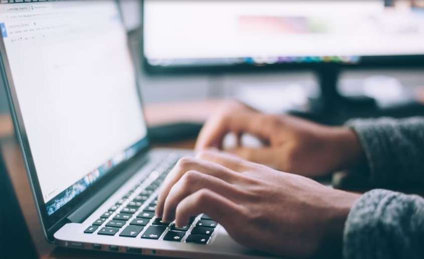 A person typing on a laptop computer.