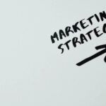 The word marketing strategy is written on a white wall.