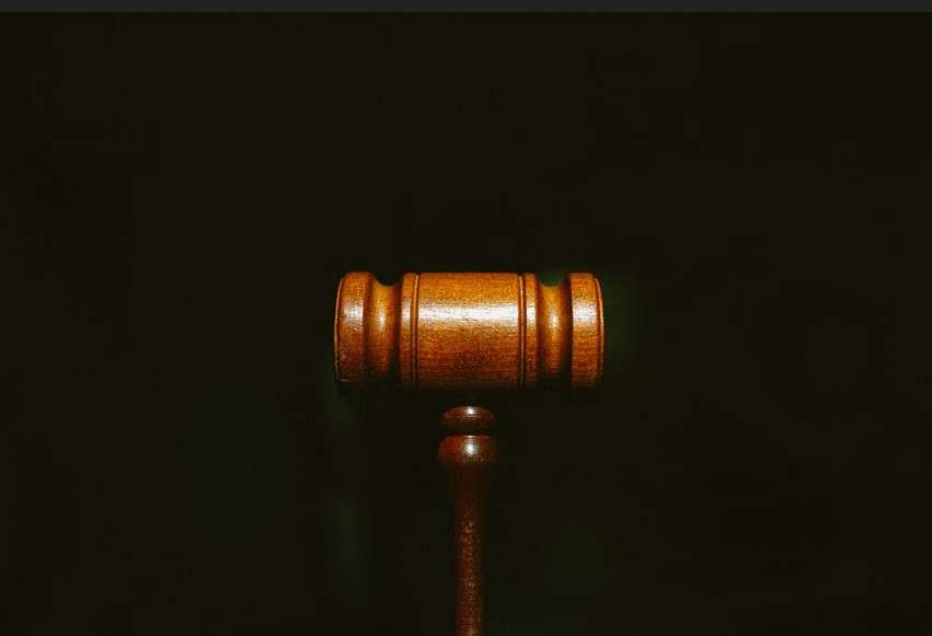 A wooden gavel on a black background.