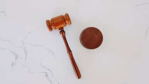 A wooden gavel and a wooden disc on a marble surface.