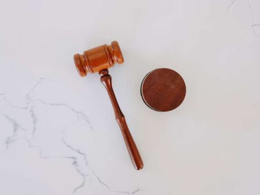A wooden gavel and a wooden disc on a marble surface.